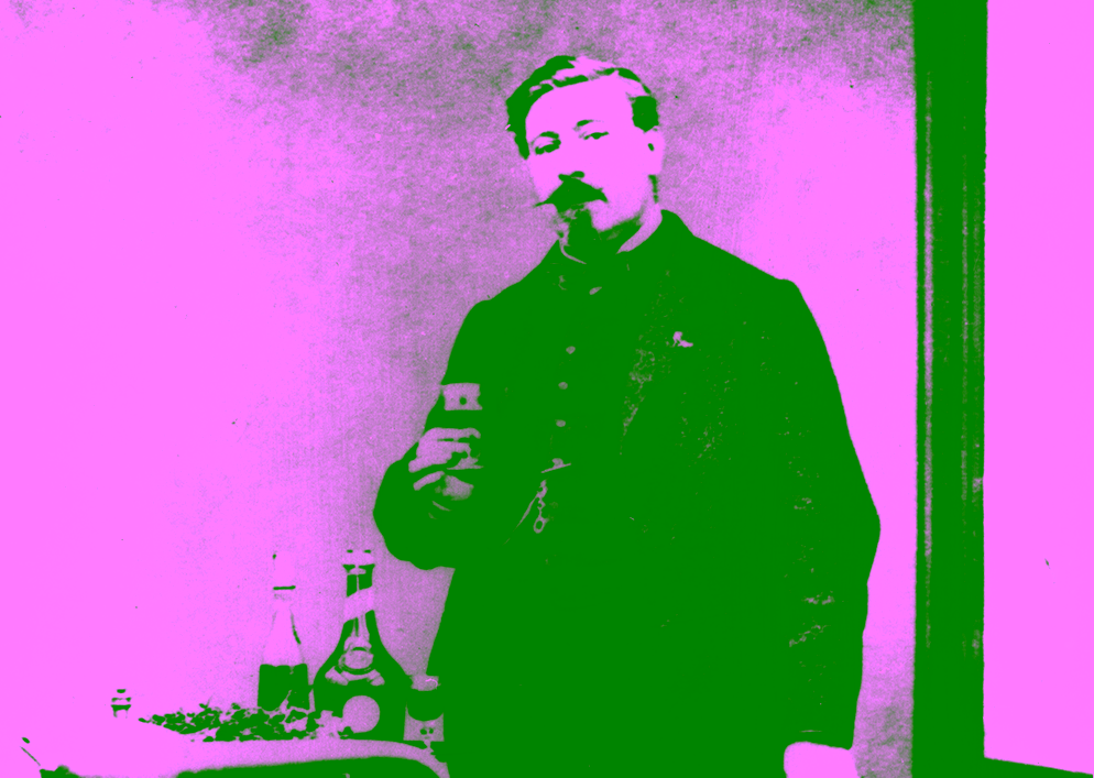 Historic photograph of Alexandre Le Grand holding a glass of Bénédictine in his laboratory.